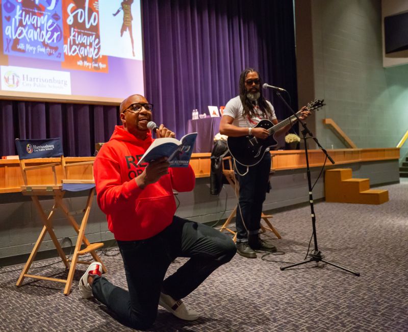 Kwame Alexander recites poetry from his book in front of auditorium