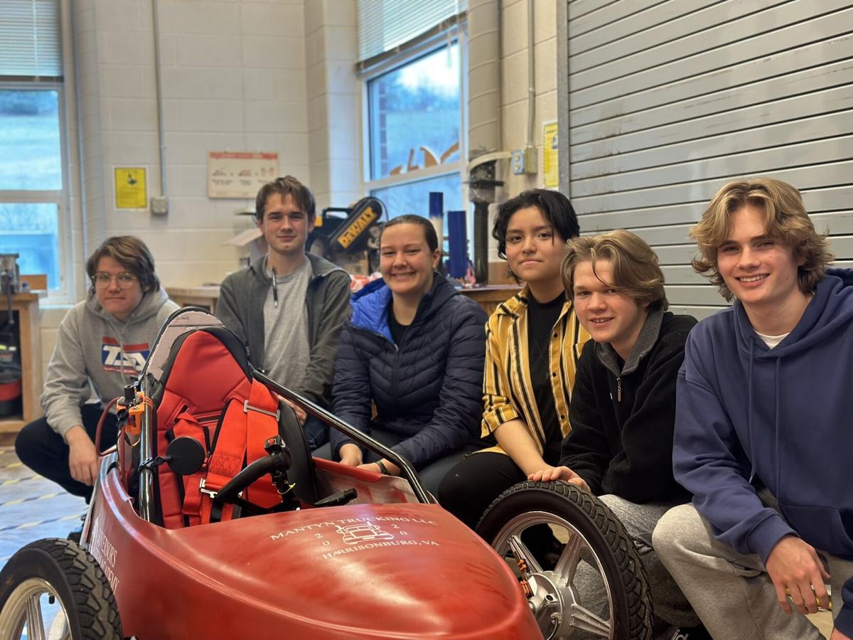 Students stand next to their electric vehicle